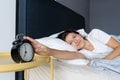 The girl turns off the annoying alarm clock to continue sleeping. Get some more sleep. It a hard morning. Time to wake up Royalty Free Stock Photo