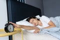 The girl turns off the annoying alarm clock to continue sleeping. Get some more sleep. It a hard morning. Time to wake up Royalty Free Stock Photo