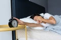 The girl turns off the annoying alarm clock to continue sleeping. Get some more sleep. Its a hard morning. Time to wake up Royalty Free Stock Photo