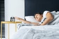 The girl turns off the annoying alarm clock to continue sleeping. Get some more sleep. It s a hard morning. Time to wake up Royalty Free Stock Photo