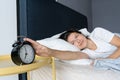 The girl turns off the annoying alarm clock to continue sleeping. Get some more sleep. It s a hard morning. Time to wake up Royalty Free Stock Photo