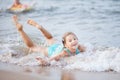 Girl in a turquoise bathing suit in the sea, happy children swimming in the sea, waves and splashes from swimming in the sea Royalty Free Stock Photo