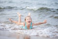 Girl in a turquoise bathing suit in the sea, happy children swimming in the sea, waves and splashes from swimming in the sea Royalty Free Stock Photo