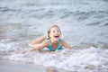 Girl in a turquoise bathing suit in the sea, happy children swimming in the sea, waves and splashes from swimming in the sea Royalty Free Stock Photo
