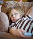 Girl with tv remote control Royalty Free Stock Photo