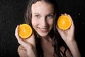 Girl with two halfs of orange in water studio Royalty Free Stock Photo