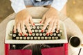 Girl typing on the old typewriter with a cup of coffee outdoors Royalty Free Stock Photo