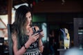 The girl typing in the phone, sitting in a cafe with fruit pineapple juice in a glass and a tube. Royalty Free Stock Photo