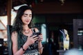 The girl typing in the phone, sitting in a cafe with fruit pineapple juice in a glass and a tube. Royalty Free Stock Photo