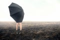 Girl with umbrella on black field Royalty Free Stock Photo