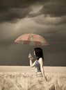 Girl with umbrella at field in retro style Royalty Free Stock Photo