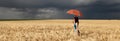 Girl with umbrella at field. in storm Royalty Free Stock Photo