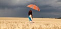 Girl with umbrella at field. in storm Royalty Free Stock Photo