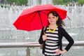 The girl with an umbrella at the fountain