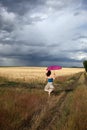 Girl with umbrella running at field Royalty Free Stock Photo