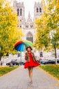 Girl with an umbrella standing at the man square or Grand Platz in Brussel, with a cathedral behind her
