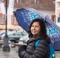 A girl with an umbrella stands on a rainy day on a street in Sibiu city in Romania Royalty Free Stock Photo