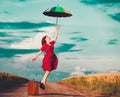 Girl with umbrella and suitcase at countryside Royalty Free Stock Photo