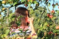 Girl under apple tree biting red apple Royalty Free Stock Photo