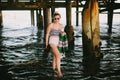 Girl under pier on beach Royalty Free Stock Photo