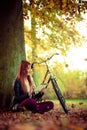 Girl under tree with bike. Royalty Free Stock Photo