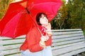 Girl under an umbrella on an old bench.