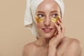 Girl with undereye patches and towel on head Royalty Free Stock Photo