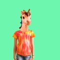 A girl with a unicorn head in a t-shirt in tie dye style on a green background. Contemporary art. Royalty Free Stock Photo