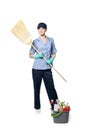 A girl in the uniform of a cleaning lady and a baseball cap is standing on a white background. She with a broom and a plastic