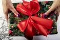 The girl unties the bow on the gift box. The concept of the new year holiday