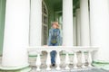 Girl in an urban denim near white balustrade