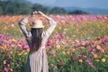 The girl uses her hand to make a heart symbol to show the love and friendship to her lover on a beautiful cosmos flower field in