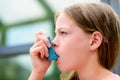 Girl uses an inhaler during an asthma attack Royalty Free Stock Photo