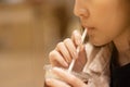 The girl uses a paper straw to suck coffee in cafe