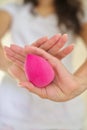 Girl uses pink beauty blender sponge in makeup, morning routine, vertical photo, beauty gadget, must have tool Royalty Free Stock Photo