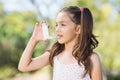 Girl using an asthma inhaler Royalty Free Stock Photo
