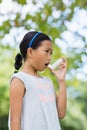 Girl using an asthma inhaler Royalty Free Stock Photo