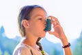 Girl using asthma inhaler in a park Royalty Free Stock Photo