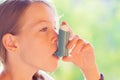 Girl using asthma inhaler in a park Royalty Free Stock Photo