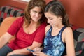 Girl using a cellphone with her mother looking Royalty Free Stock Photo