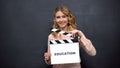 Girl using clapperboard with word Education, start of school year, graduation