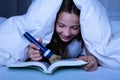 Girl Using Flashlight While Reading Book Royalty Free Stock Photo