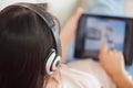 Girl using her tablet on the sofa and listening to music Royalty Free Stock Photo