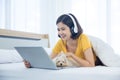 A girl is using a laptop computer with a Maltese dog in her bedroom Royalty Free Stock Photo