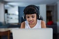 Girl using laptop while listening music from headphones Royalty Free Stock Photo