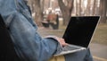 Girl using laptop outside in park. Woman working on laptop computer in public park during covid-19 coronavirus quarantine. Freelan