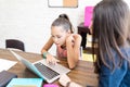 Girl Using Laptop While Tutor Assisting Her At Home