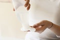 Girl using micellar water product with cotton pads for removing make up on a pastel beige yellow cream background.