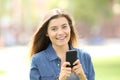 Girl using mobile phone and looking at you Royalty Free Stock Photo
