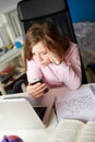 Girl Using Mobile Phone Instead Of Studying In Bedroom Royalty Free Stock Photo